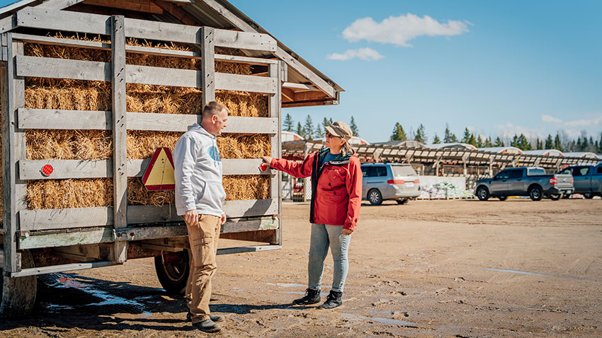 Kristine and Farmer Chris beside Hay Wagon